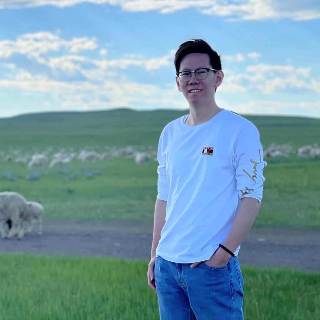 Xiaoshi Wang stands in a field.